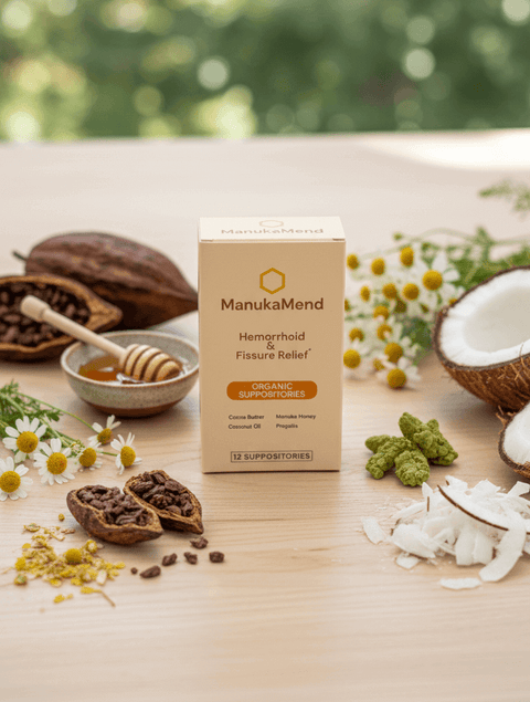 ManukaMend Organic Suppositories for Anal Relief packaging with natural ingredients and honey on wooden table.